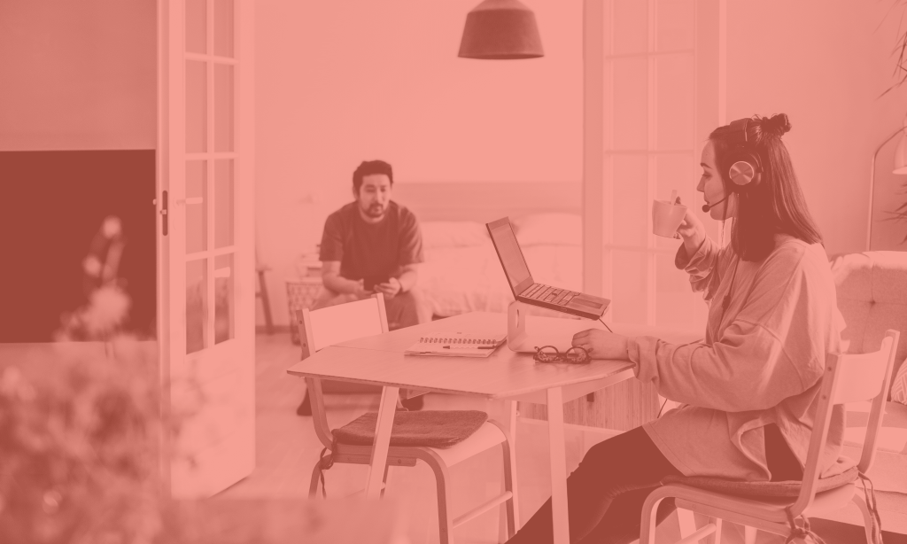 Woman at a desk and man sitting on sofa working flexibly from home.