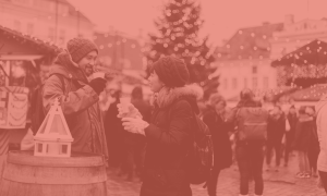 fun, festive activities: a man and woman enjoying a hot drink at a christmas market